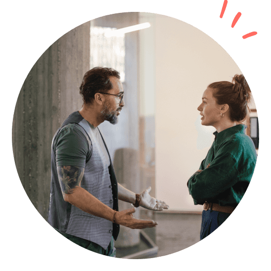 To personer står og diskuterer.