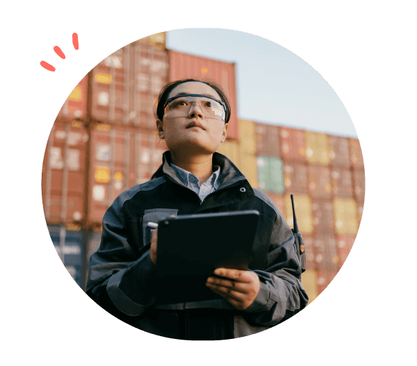 Kvinne med ipad som står foran konteinere