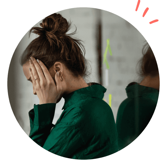 Dame som holder seg til hodet og er tydelig sliten.