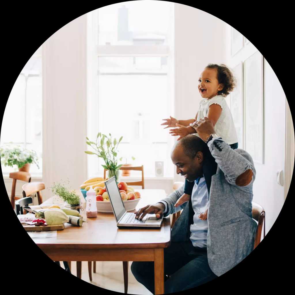 Mann som jobber hjemmefra med en datter på skulderene.